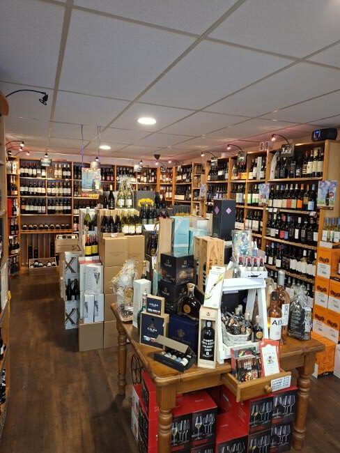 overzicht slijterij met wijn sterke drank en cadeaupakketten rijen