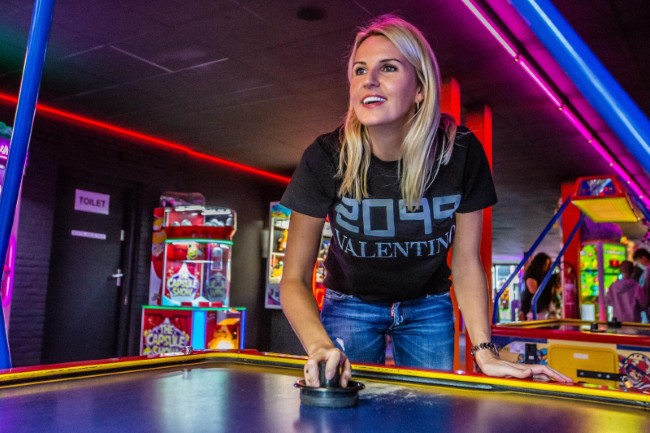 jonge vrouw speelt airhockey in de arcadehal van lets play it etten leur