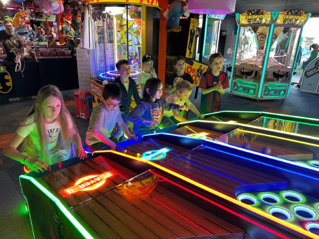 kinderen spelen skeeball in de kleurrijke gamehal van lets play it etten leur