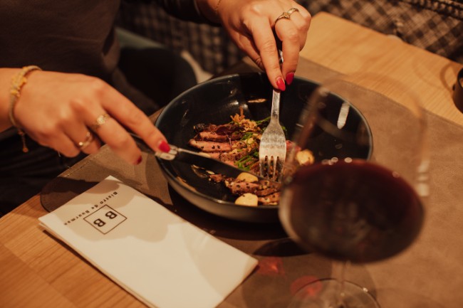 Genieten van een gerecht met rode wijn bij Bistro de Buurman Breskens