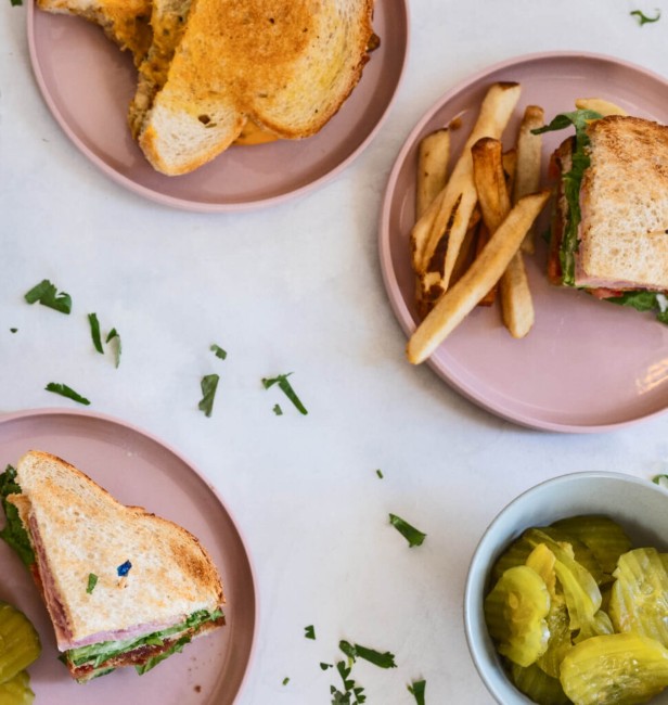 lunchtafereel met sandwiches friet en augurken op roze borden