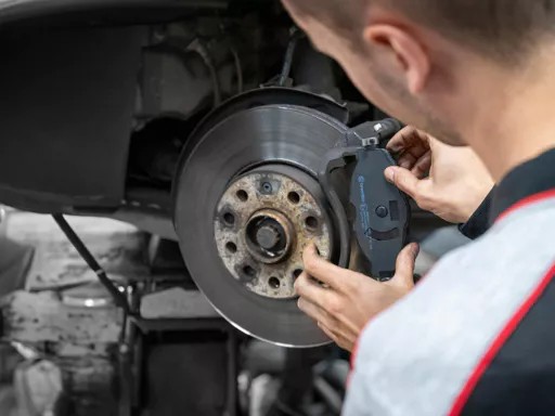 monteur vervangt remblokken van auto