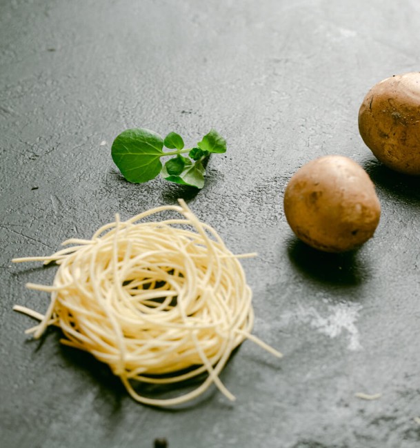 rauwe ingredienten met spaghetti aardappels en winterpostelein