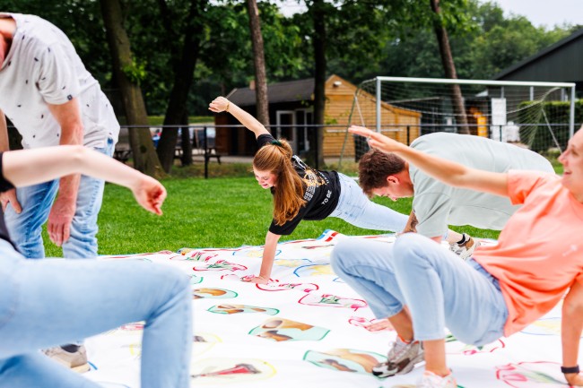 twister spel buiten met groep vrienden op grasveld