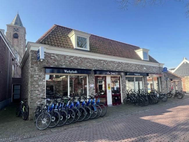 buitenkant van fietsenwinkel leo joosse met fietsen voor de deur