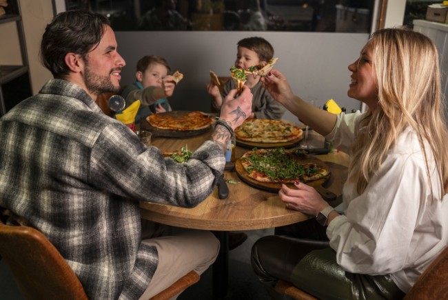 gezin geniet samen van verse pizzas in een italiaans restaurant