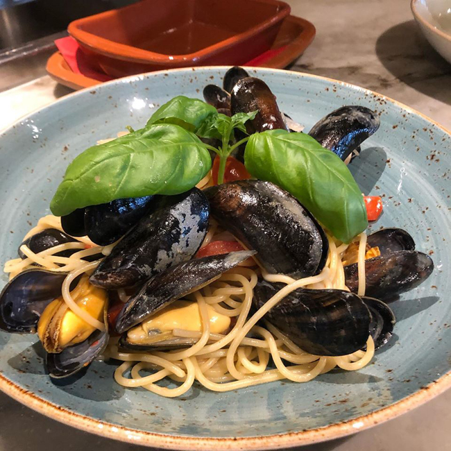 Spaghetti met mosselen in een kruidensaus, een smaakvol gerecht beschikbaar bij La Pergola.