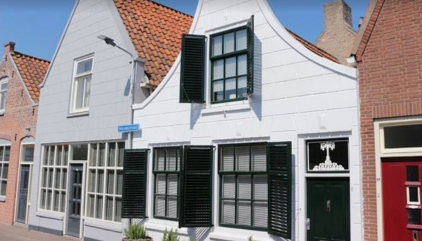Traditionele Nederlandse huizen langs een geplaveide straat in Brouwershaven, Zeeland