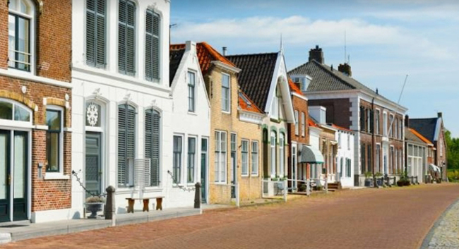 Traditionele Nederlandse huizen langs een geplaveide straat in Brouwershaven, Zeeland.
