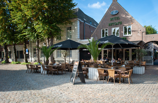 Buitenterras van Hotel De Bengel met parasols op het stadsplein in Eersel