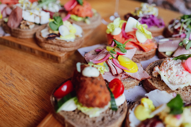 Diverse luxe belegde broodjes op houten planken geserveerd bij Restaurant Bij Wout in Moergestel