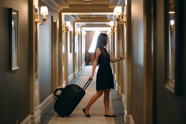 Vrouw met koffer loopt door de gang van Hotel Den Engel in Baarle Nassau