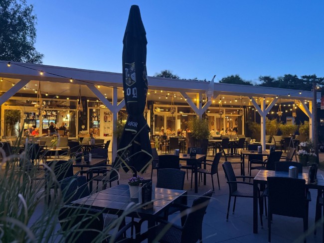 gezellig verlicht terras van gasterij de grenshoeve bij schemering