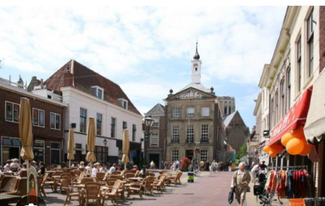 Terras met mensen die genieten van het zonnetje in het centrum van Brielle