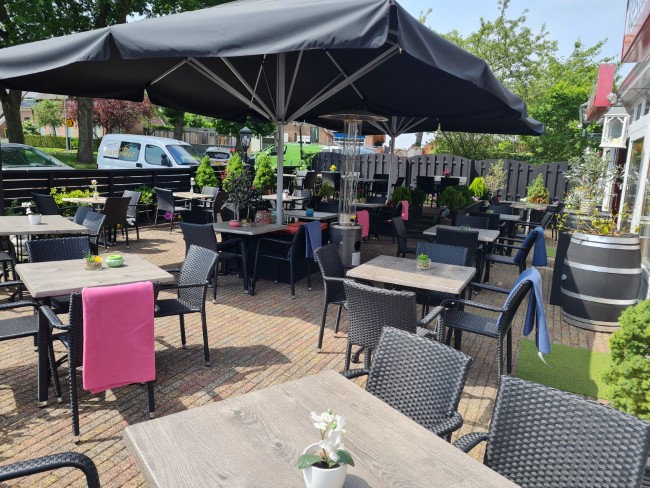 gezellig terras bij pizzeria en grill la bella borger met moderne parasols en kleurrijke details