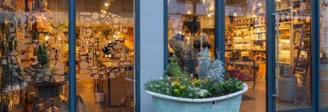 bianca bonte kookwinkel oostburg gevel met verlichte winkelruit en bloemen