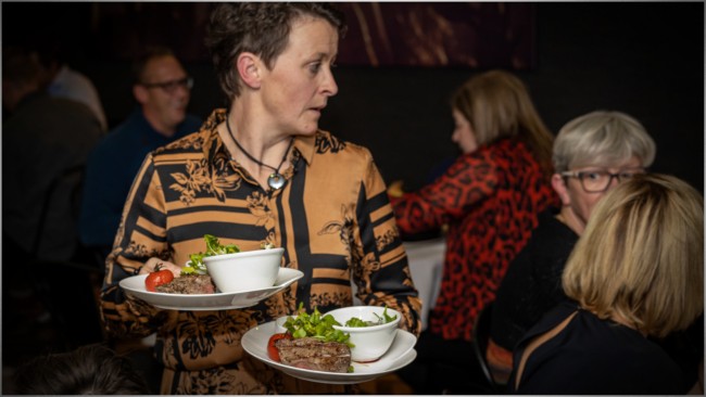 brasserie retie den triptiek serveerster met vleesgerechten aan tafel