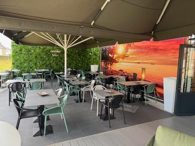 zonnig buitenterras van taverne westhoek balen met uitzicht op sfeervolle zonsondergangmuur