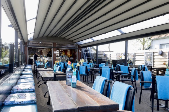 Overdekt terras met blauwe accenten bij De Marlijn in Renesse