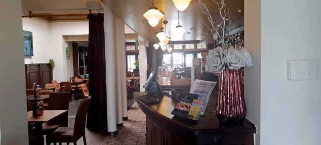 brasserie inkom met balie en verlichte bar in klassieke stijl