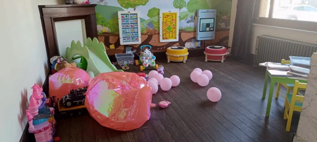 brasserie speelhoek voor kinderen met glijbaan en roze ballonnen