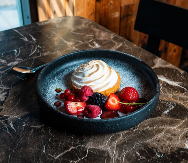 dessert met meringue en vers rood fruit op marmeren tafel