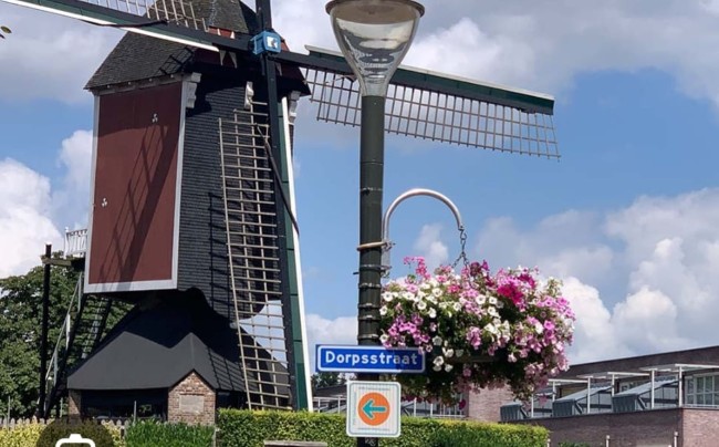 dorpsstraat mierlo met houten windmolen en bloemen