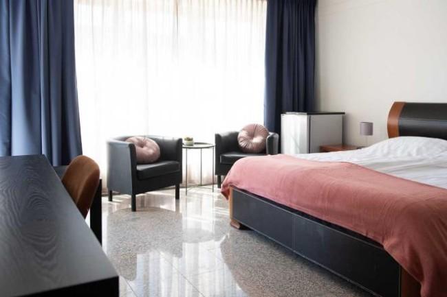 lichte hotelkamer met zithoek en minibar