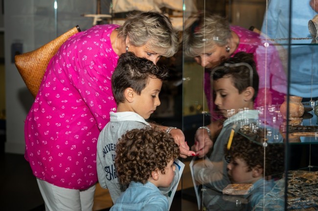 oma en kleinkinderen bekijken museumvitrine