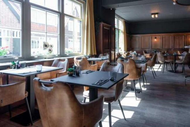 stijlvol restaurant met leren stoelen en grote ramen