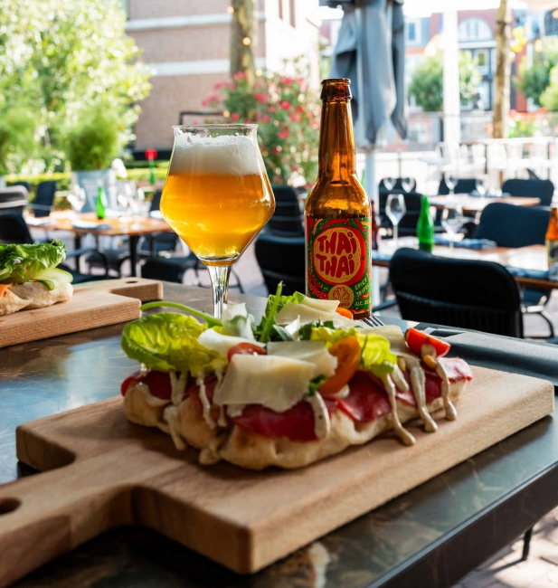 verfrissend speciaalbier met focaccia op terras op zonnige dag