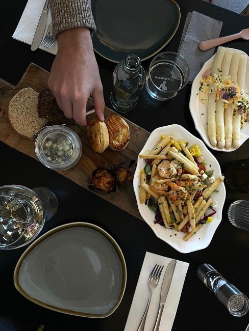 borden met verse salade en witte asperges bij de gasterij