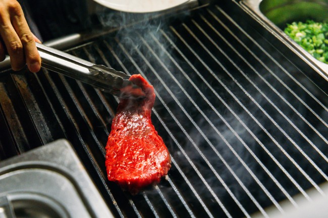 verse biefstuk op de grill met stoom en tang