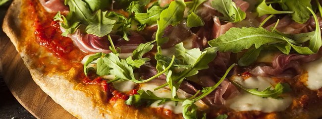 verse pizza met prosciutto en rucola naast het menu van del limone