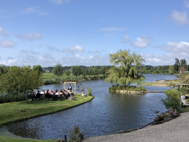 buitenbruiloft aan het water met natuurlijk decor