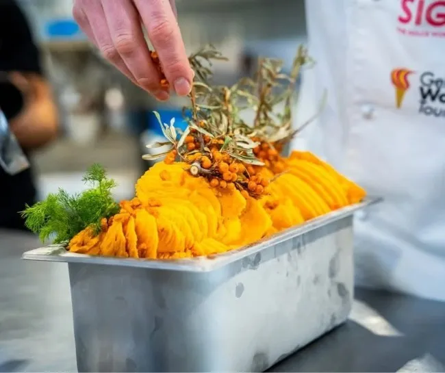 ambachtelijk bereid oranje ijs met decoratie wordt afgewerkt