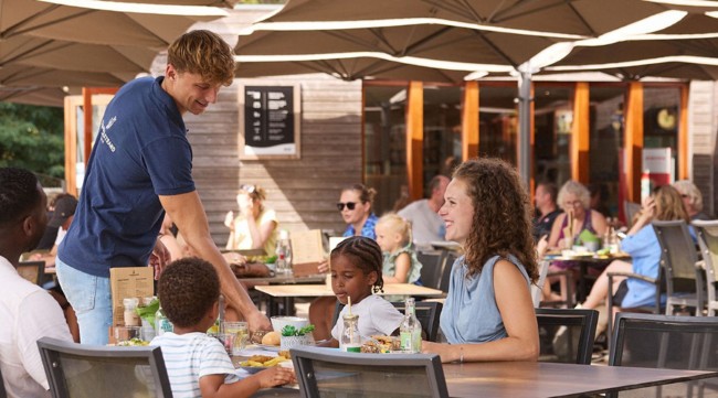 gezin geniet samen op het zonnige terras van brasserie t smokkelstrand in chaam