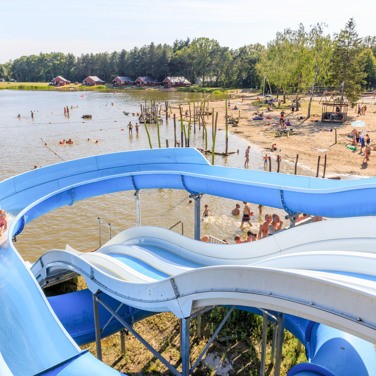 waterpret op de glijbaan bij het recreatiemeer op een zonnige dag