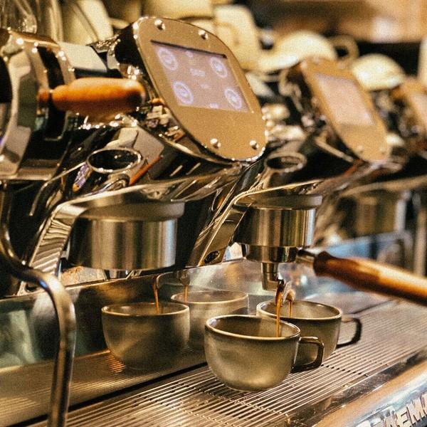 barista maakt meerdere kopjes espresso in moderne koffiemachine