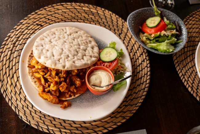 pita broodje met kip groenten en saus op bord
