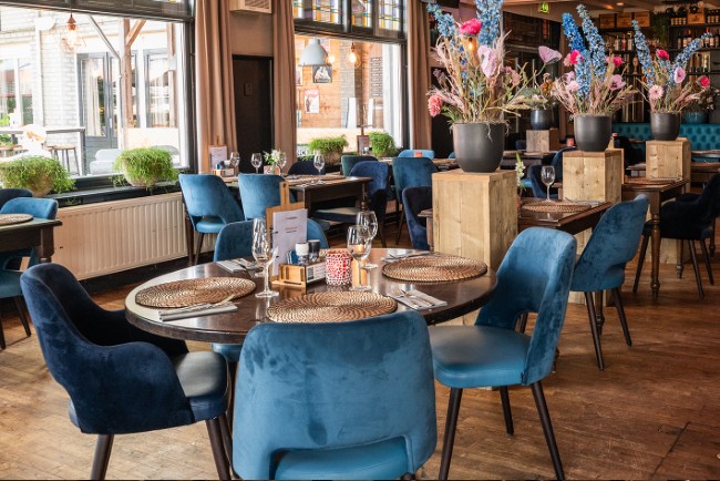 sfeervol restaurant interieur met blauwe stoelen en houten tafels