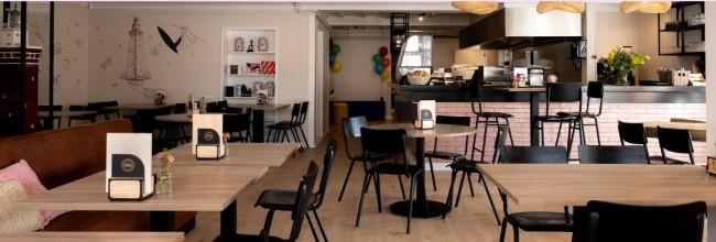 modern cafe interieur met houten tafels en open keuken