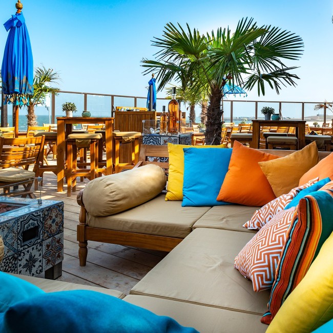 sfeervol lounge terras met kleurrijke kussens aan zee in scharendijke