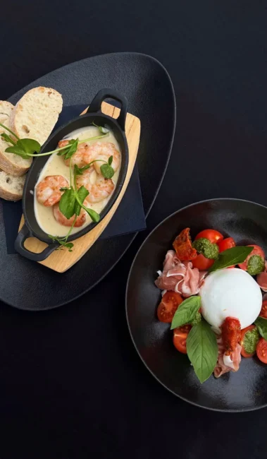 Garnalen in romige saus met brood; bord burrata met cherrytomaat, prosciutto en basilicum bij Eetcafé Hart van Tholen