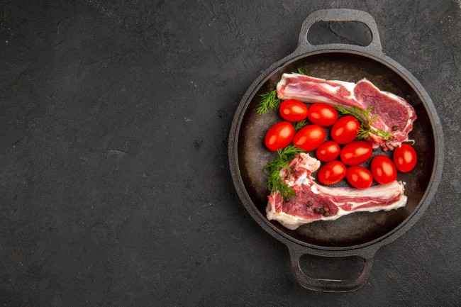 bistro moen poppel verse tomaten en vlees in gietijzeren pan